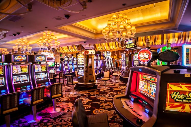 An interior view of a casino showcasing various slot machines under bright lights.